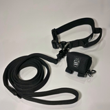 Black dog collar, matching nylon leash, and portable poop bag dispenser set displayed on a white background.