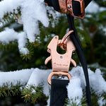 Black PVC dog leash clipped to a matching 1-inch PVC dog collar with rose gold hardware, displayed against a snowy evergreen branch.
