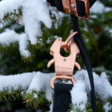 Black PVC dog leash clipped to a matching 1-inch PVC dog collar with rose gold hardware, displayed against a snowy evergreen branch.
