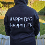 Person wearing a Bully Wags hoodie with the phrase "Happy Dog, Happy Life" outdoors.