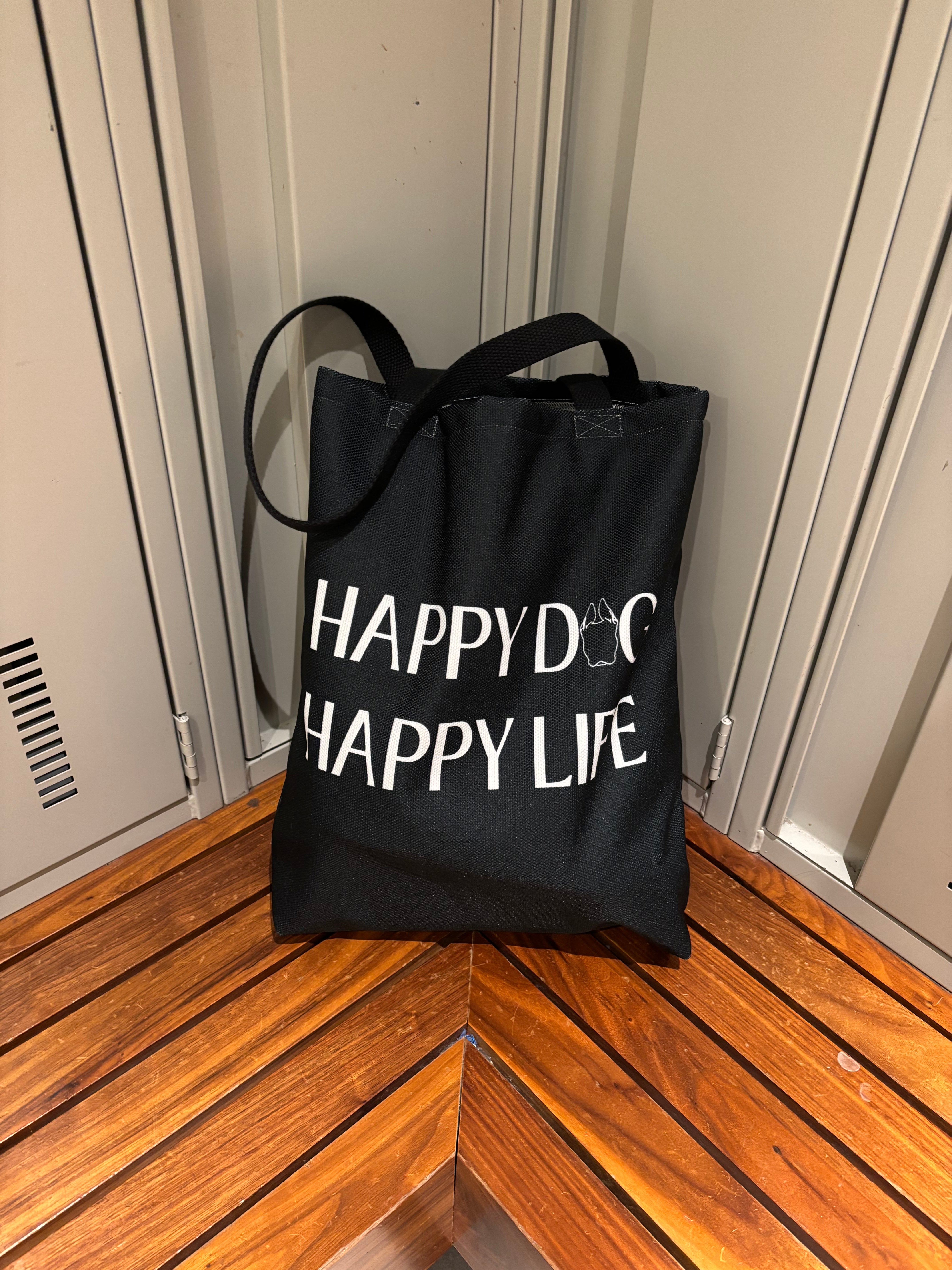 Bully Wags tote bag with the phrase "Happy Dog, Happy Life" displayed on a wooden bench