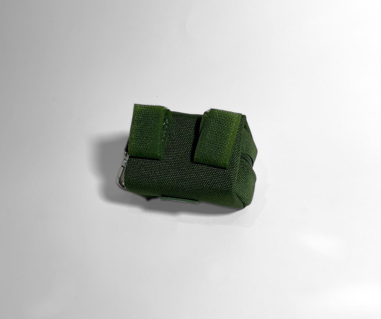 Cactus green portable poop bag dispenser showing the hook-and-loop attachment straps for securing the dispenser to a leash or bag.