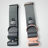 Black waterproof PVC dog collars displayed side by side, featuring black hardware on one collar and rose gold hardware on the other, on a light gray background.