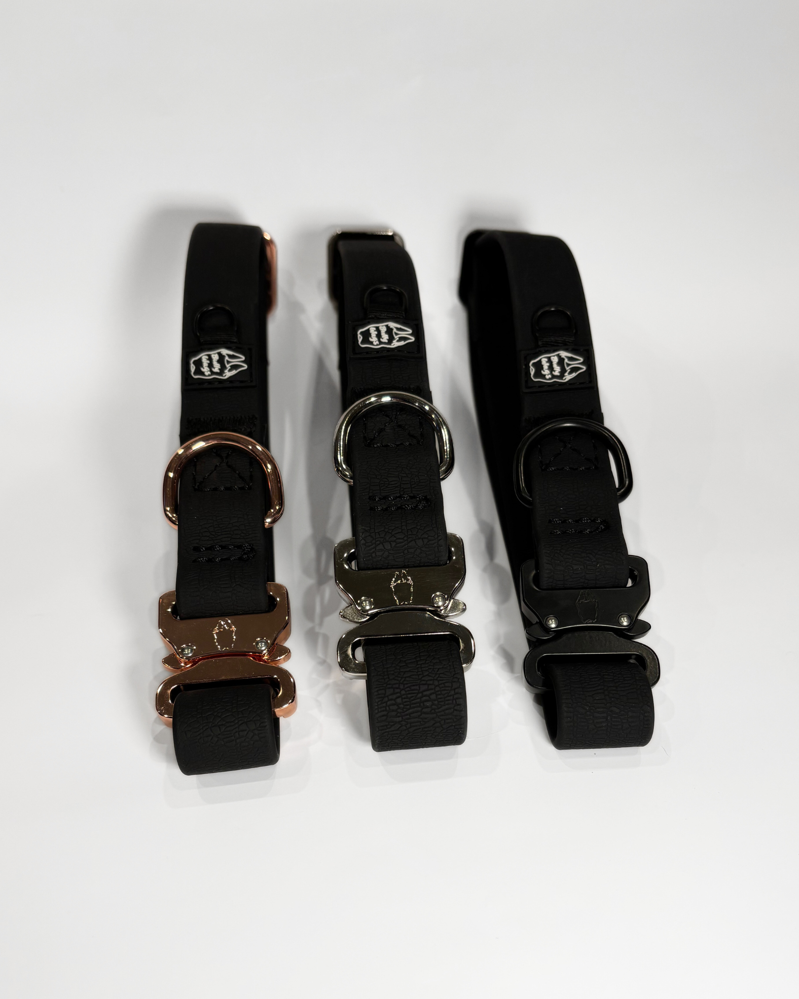 Black 1-inch waterproof PVC dog collars with rose gold, silver, and black hardware, displayed side by side on a light gray background.